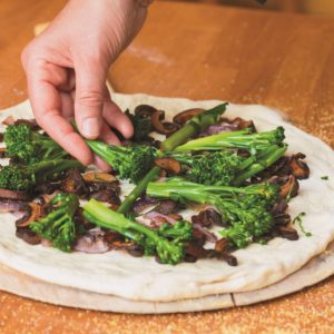 Assembling the Broccoli Rabe Pizza.