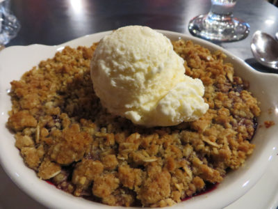 Warm berry crisp with creamy ice cream Berry crisp topped with a scoop of vanilla ice cream