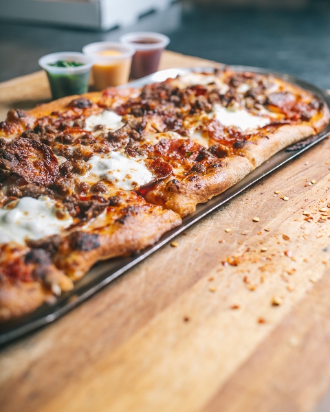 Pizza with sauces at Slim & Husky's Pizza