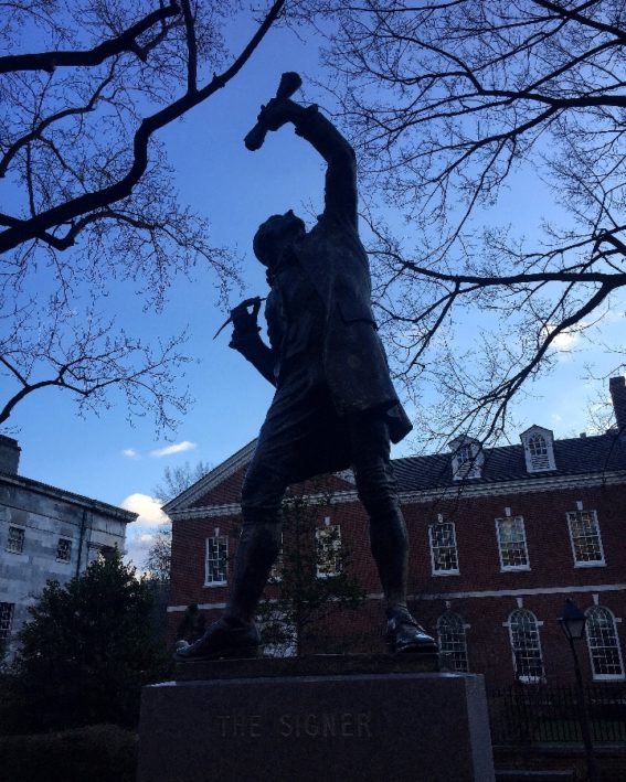 A statue honoring the signers of the Declaration of Independence next to Independence Hall, a Philadelphia historical site.