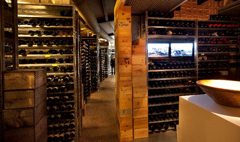 The wine cellar at El Celler de Can Roca, with rows of bottles in wooden shelves.