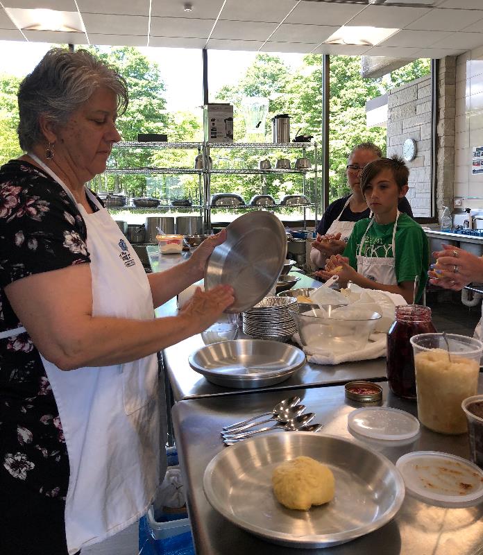 A class learning how to make Belgian cherry pie.