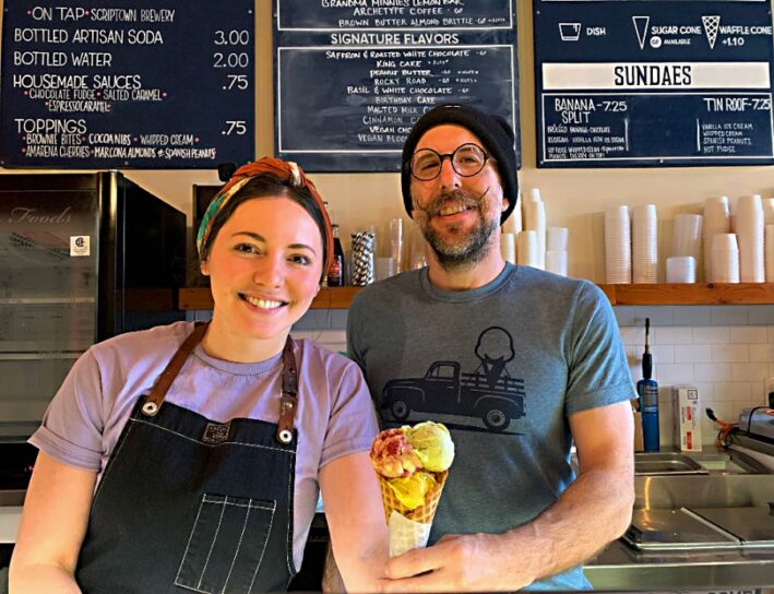man and woman holding ice cream cone.