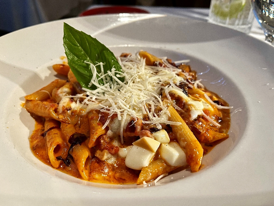 Pasta with tomato sauce and squares of cheese.
