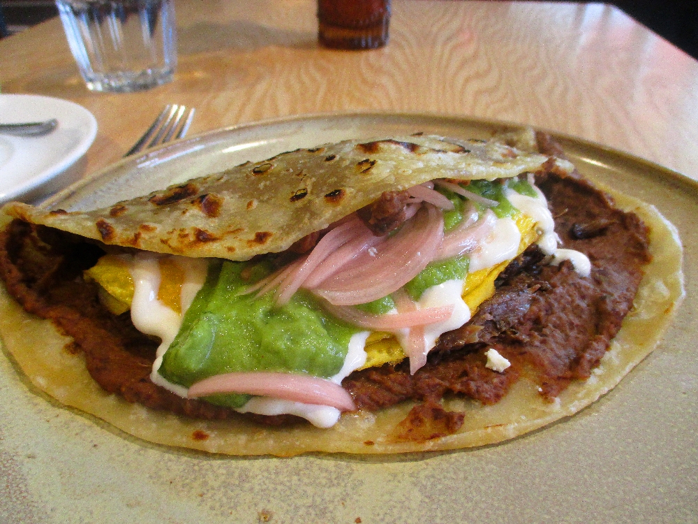 Honduran Baleadas: tortilla, short ribs, scrambled eggs, refried beans, cotija cheese, avocado, lime crema and pickled onions.