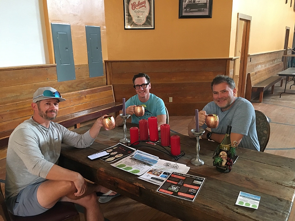Three men who are enjoying being at the distillery