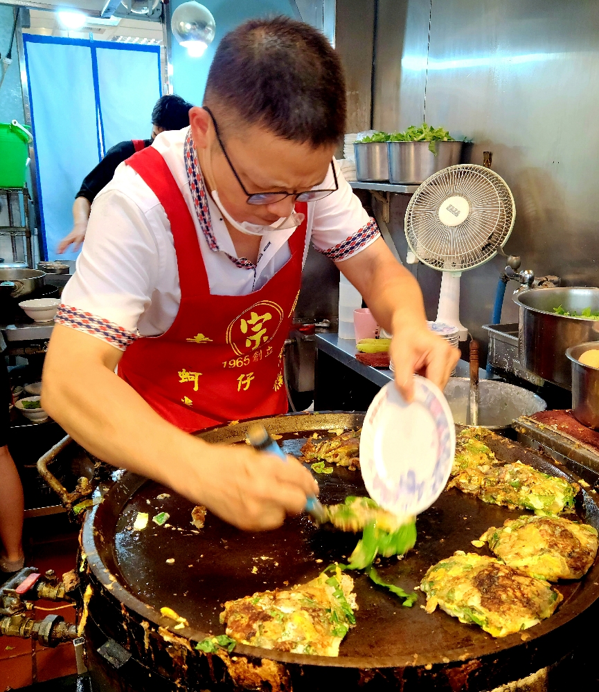 A Taiwanese street vendor prepares oyster omeletes in the Night Market.