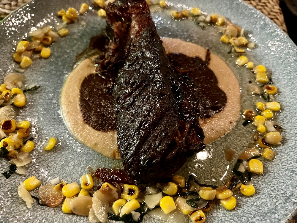 Braised beef rib with grilled plantain puree, corn, nuts and a light mole sauce from De Cortez.