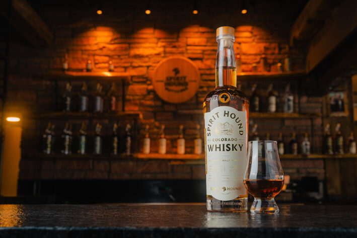 A bottle and glass of a Spirit Hound product.