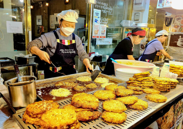 Grilling mung bean pancakes at Gwangjang Market in Seoul.