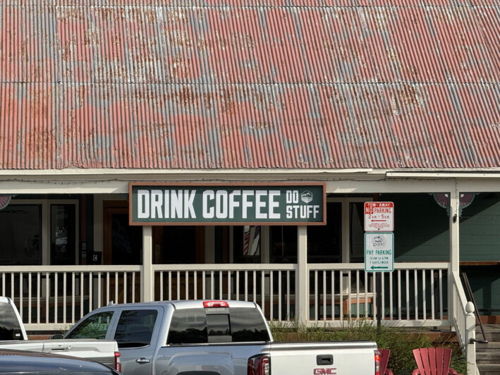 Drink Coffee Do Stuff sign on building. By Carole Jacobs.