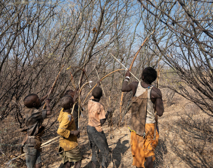 Boys hunting with bows and arrows.