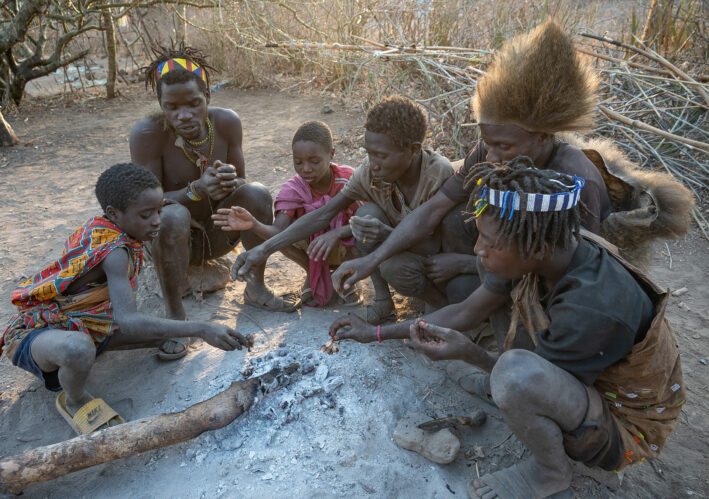 Men and boys from the Hadzabe tribe eating what they've hunted.