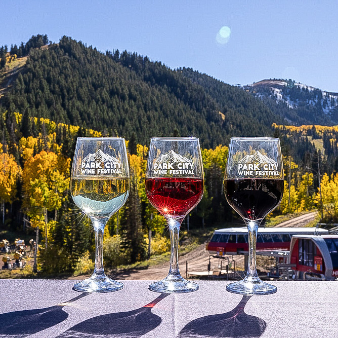 Three wine glasses in front of view at Park City Wine Festival.