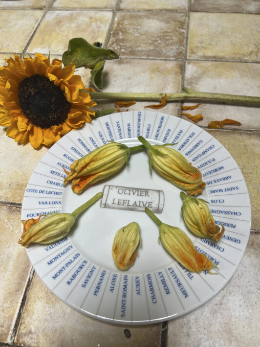 zucchini blossoms on a plate with a sunflower